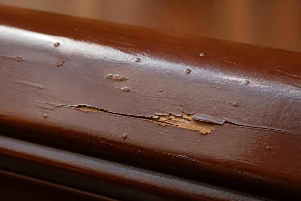 Zbliżenie na łuszczącą się brązową farbę i uszkodzenia drewnianej powierzchni
